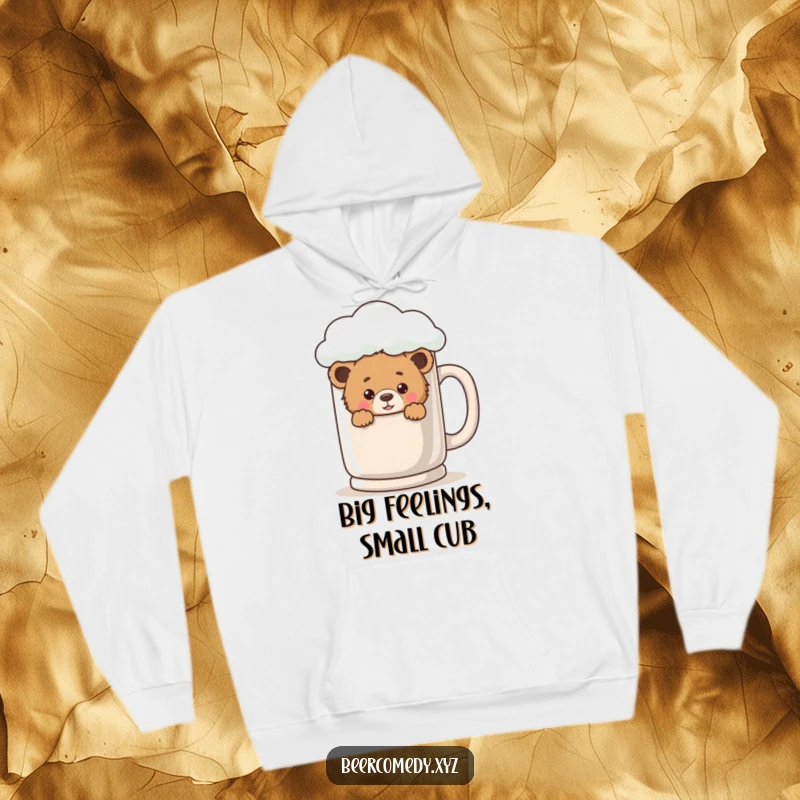 A charming bear cub peeks out from behind a large, frothy mug, printed on a comfortable and warm hoodie.