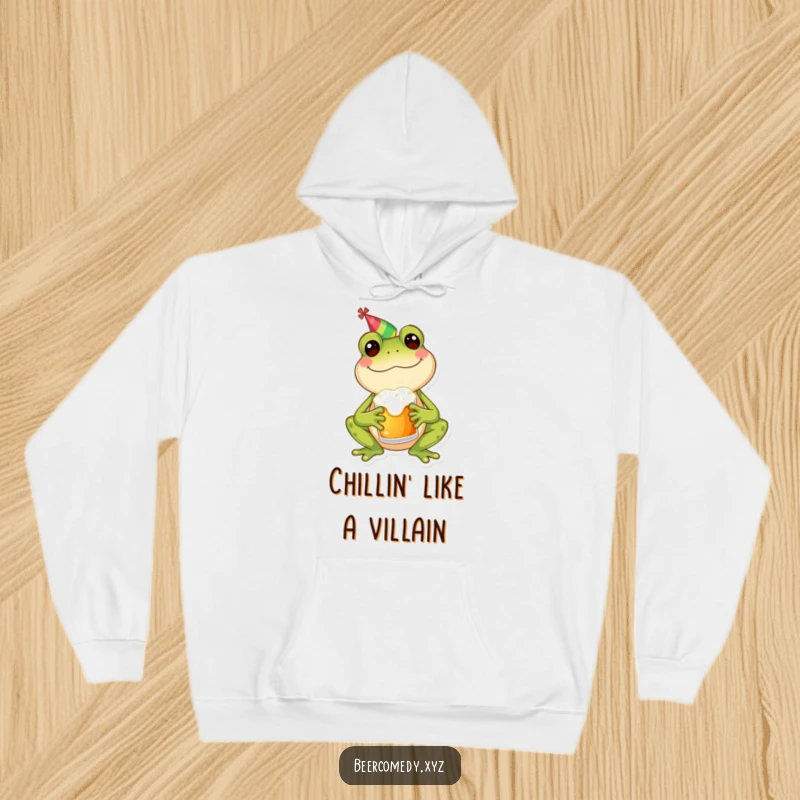 Funny frog in a party hat holding a frothy mug, looking happy and cozy, printed on a warm and comfortable hoodie.